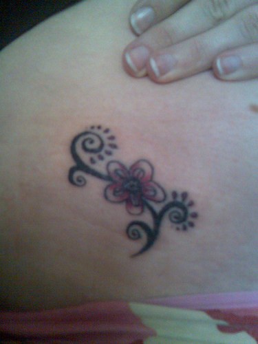 Tatuaje en la cadera, flor con tallo rizado