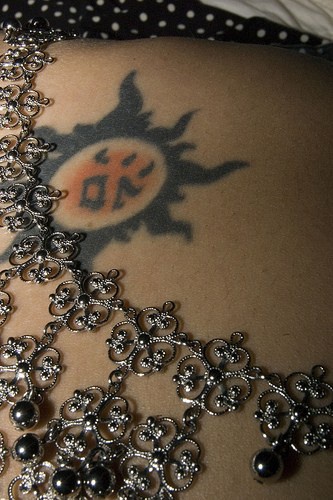 Il sole in stile tribale tatuato