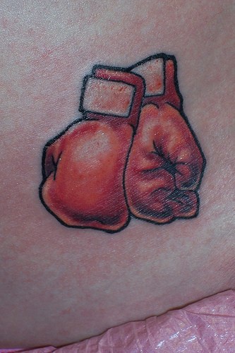 Tattoo von zwei Boxhandschuhen an der Hüfte