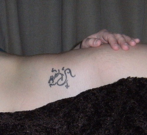 Curled styled  , strange, black image hip tattoo