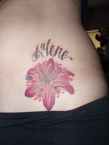 Pink lily and designed name hip tattoo