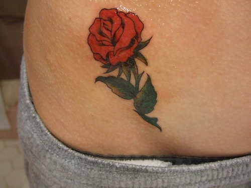 Tattoo von schöner malerischer Rose an der Hüfte