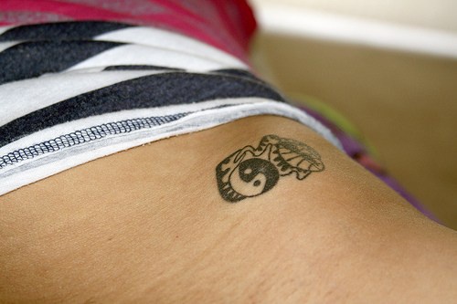 Sign male-female colorless hip tattoo
