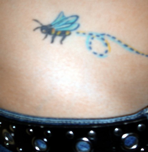 Tatuaje en la cadera, abeja con hilo azul