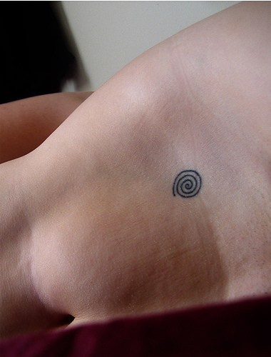 Piccola spirale tatuata sulla pancia