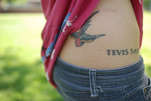 Swallow flying down, name hip tattoo