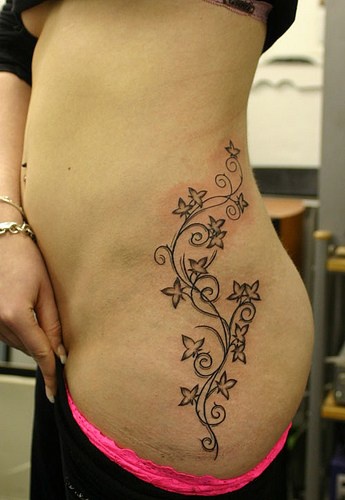 Pattern of flowers and curls hip tattoo