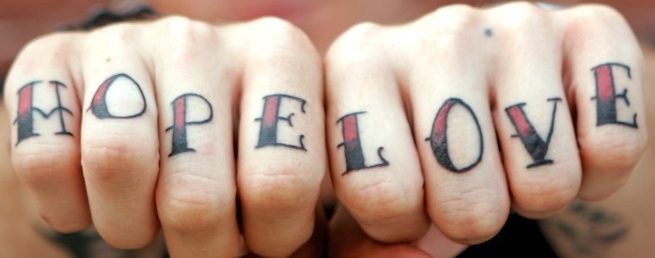 La scritta &quotHOPE LOVE" tatuata sulle dita