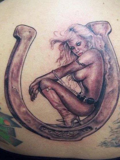 Le tatouage de fer à cheval et une femme sexy