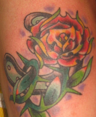rosa con  spine sul braccio colorato tatuaggio