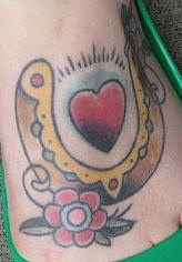 Tatuaje multicolor de una herradura con corazon dentro