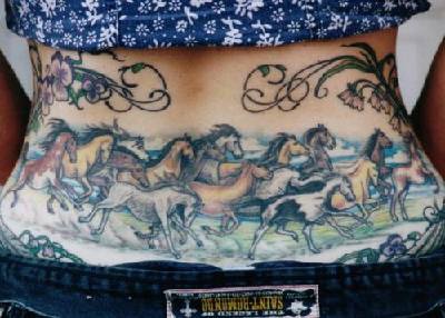 Tatuaje en la espalda de una manada de caballos coloreados.