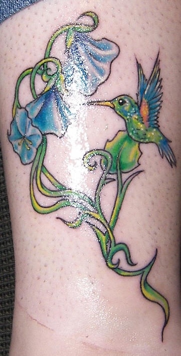 Tatuaje multicolor de un colibrí y las flores