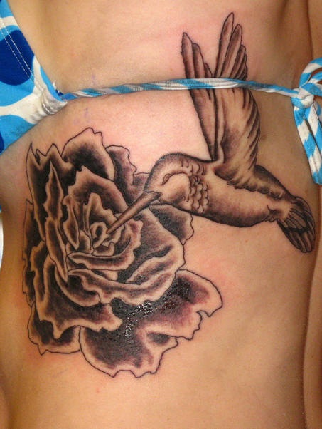 Hummingbird on rose black ink tattoo