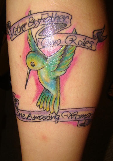 Tatuaje de un colibrí verde y unas frases