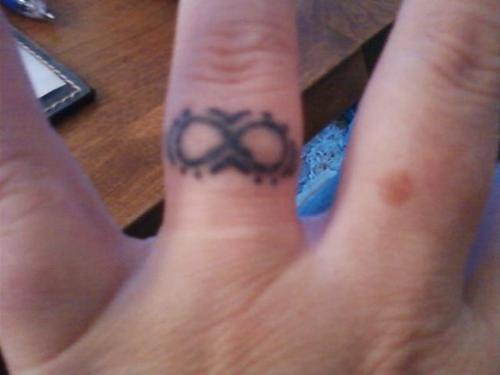 piccolo simbolo infinito sul dito tatuaggio