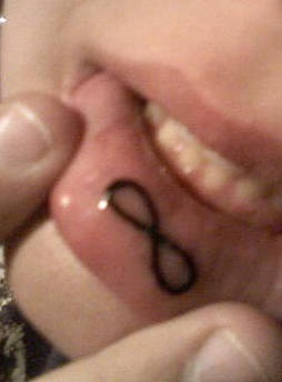Infinity symbol tattoo on inner lip