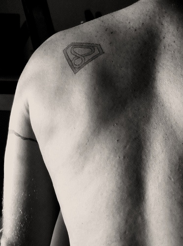 superman simbolo infinito piccolo sulla spalla tatuaggio