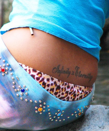 Infinity text tattoo on lower back