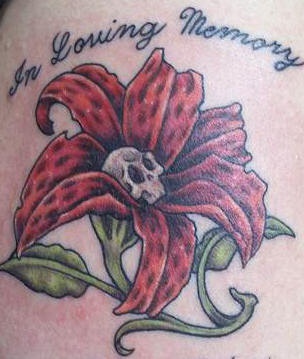 El tatuaje conmemorativo &quoten la memoria" con una flor de lirio hecho en color