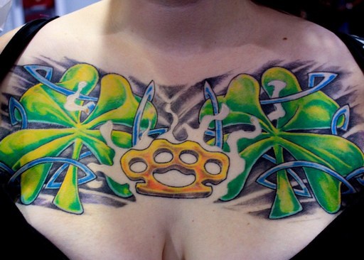 Knuckle-duster and shamrocks chest tattoo