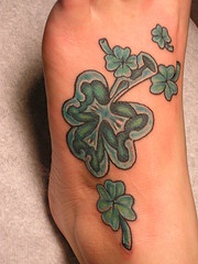 Tatuaje en el pie de unos tréboles verdes