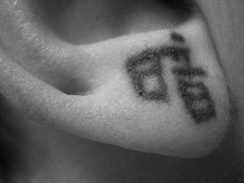 Le tatouage d&quothiéroglyphe japonais sur le lobe de l&quotoreille