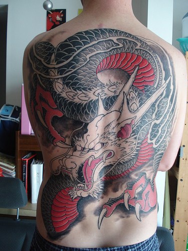 Un gros tatouage de dragon japonais en vol sur le dos