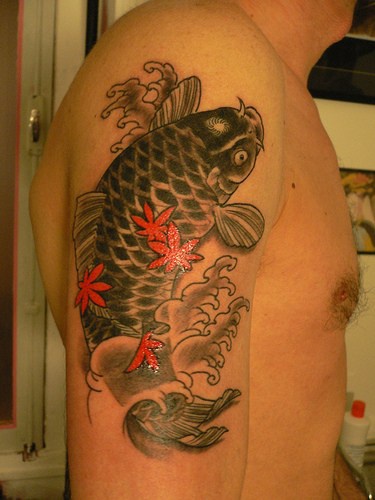 Le tatouage de koï noir et des feuilles rouges