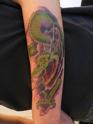 drago verde giapponese sul braccio tatuaggio