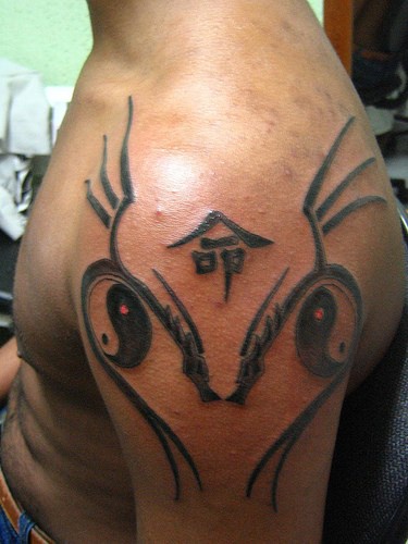 tribale stile asiatico yin yang tatuaggio