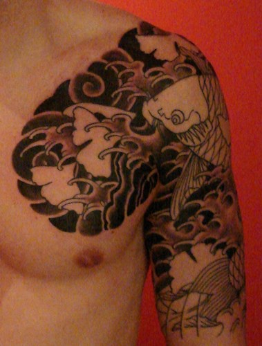 Tatuaje negro de estilo japonés en el hombro y el pecho