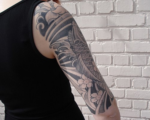 Tatuaje negro en el brazo de una carpa koi