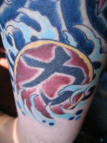 simbolo giapponese nelle onde del mare tatuaggio