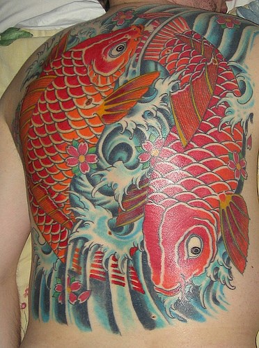 Tatuaje estilo japones en toda espalda. Dos peces formando yin yang