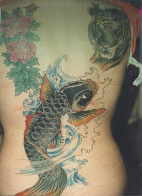 Un gros tatouage de carpe coï dans le mer avec un tigre avec les fleurs