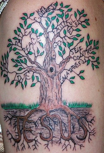 Tatuaje de una arbol con raíces formando el nombre Jesús