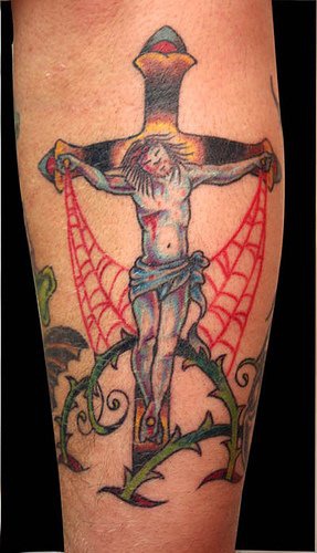 Le tatouage de Jésus crucifié avec des injures