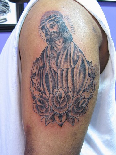 Le tatouage de Jésus dans le voil avec des roses