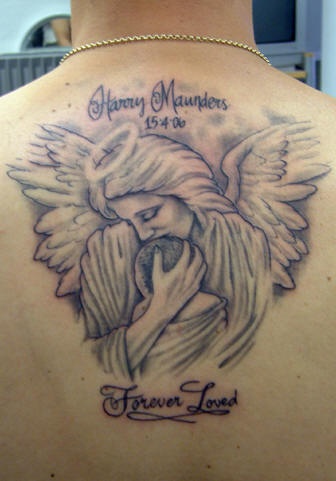 Tatuaje en espalda de un ángel abrazando un niño