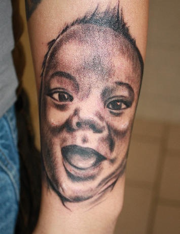 Smiling baby face tattoo