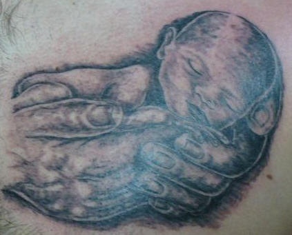 Tatuaje de niño recien nacido en las manos