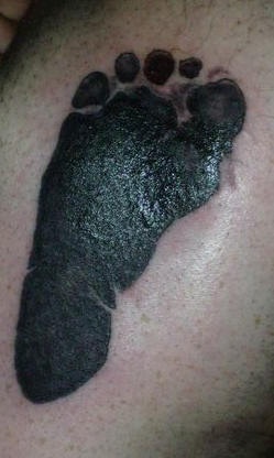 Le tatouage d&quotempreinte de pied d&quotenfant en noir