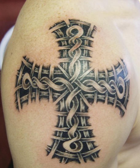 Negro tatuaje en hombro con cruz con tracería