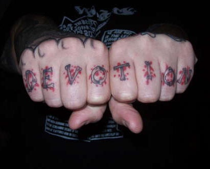 Tattoo &quotDevotion" mit stilisierten roten Flecken an Fingerknöcheln