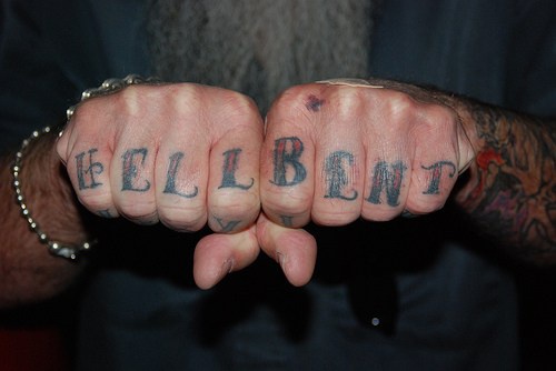 La scritta &quotHELL BENT" tatuata sulle dita