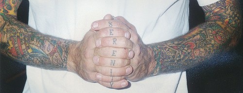 Senkrechtes Tattoo &quotSerenity" dünn geschrieben an Fingerknöcheln