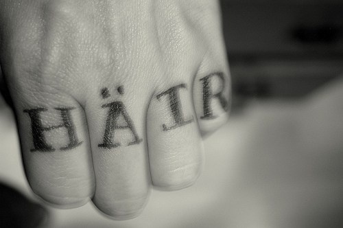 La scritta &quotHAIR" tatuata sulle dita