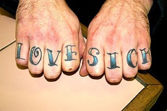 Knuckle tattoo, love sick, blue designed inscription