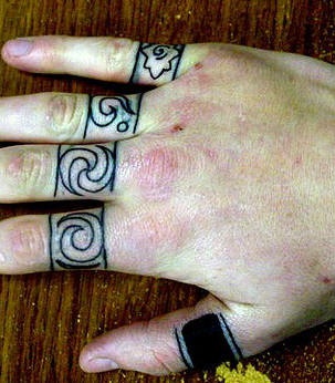 Tattoo mit verschiedenen stilisierten Ringen an Fingerknöcheln
